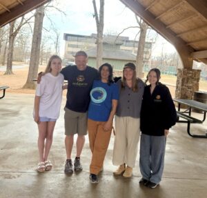 Five members of the Solgave team at a dog-walking training course under a park pavilion.